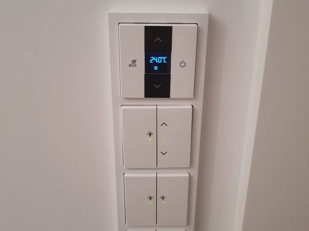 Weißes Bedienfeld mit Display zeigt 24 Grad und Tasten leuchten grün