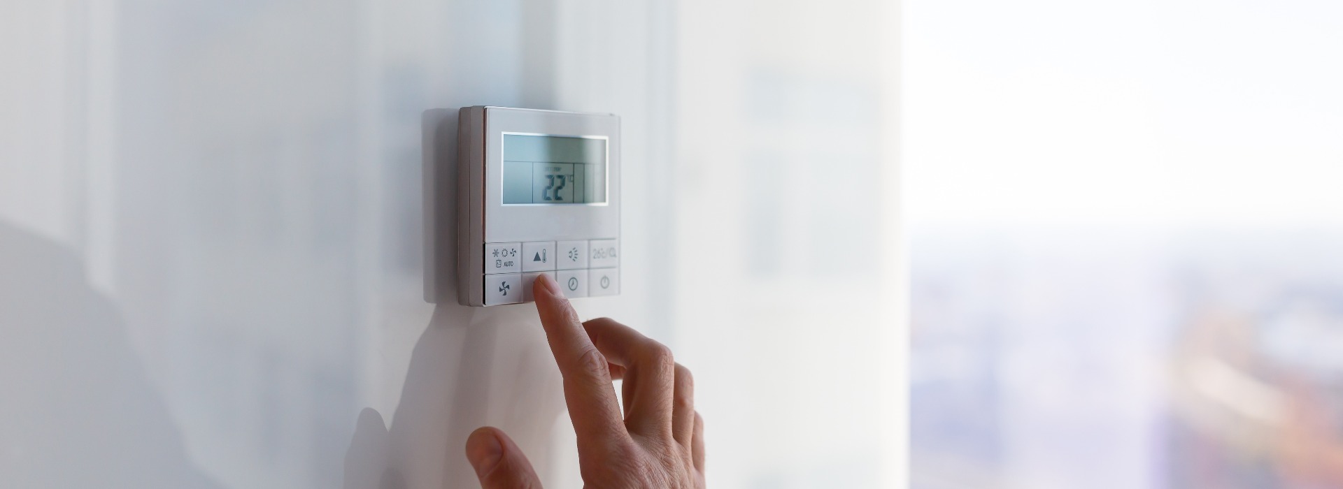 Das Bedienfeld für die Klimaanlage und Heizung der Wohnung und des Büros befindet sich an einer weißen Wand.