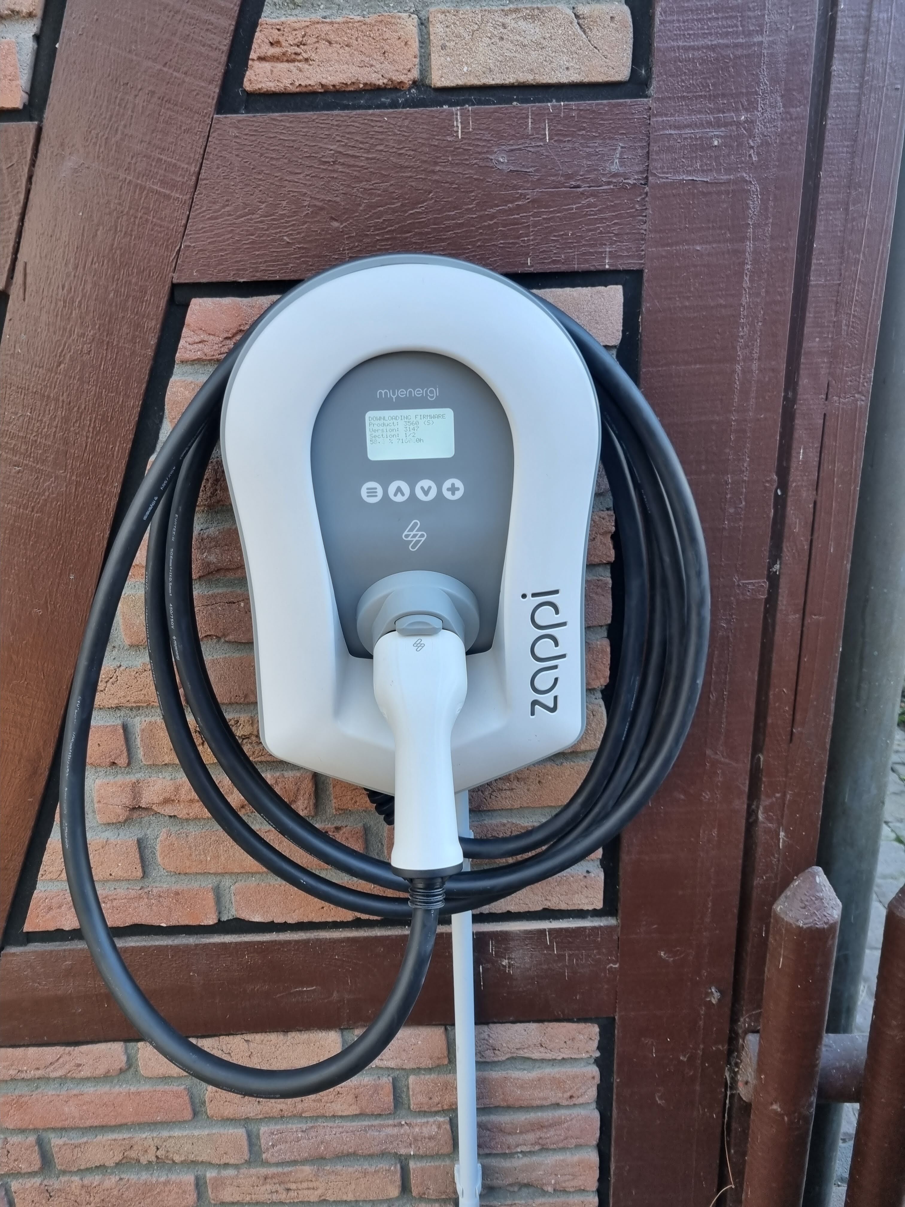 Eine weiße Wallbox zum Laden von Elektroautos hängt an einer gemauerten Wand