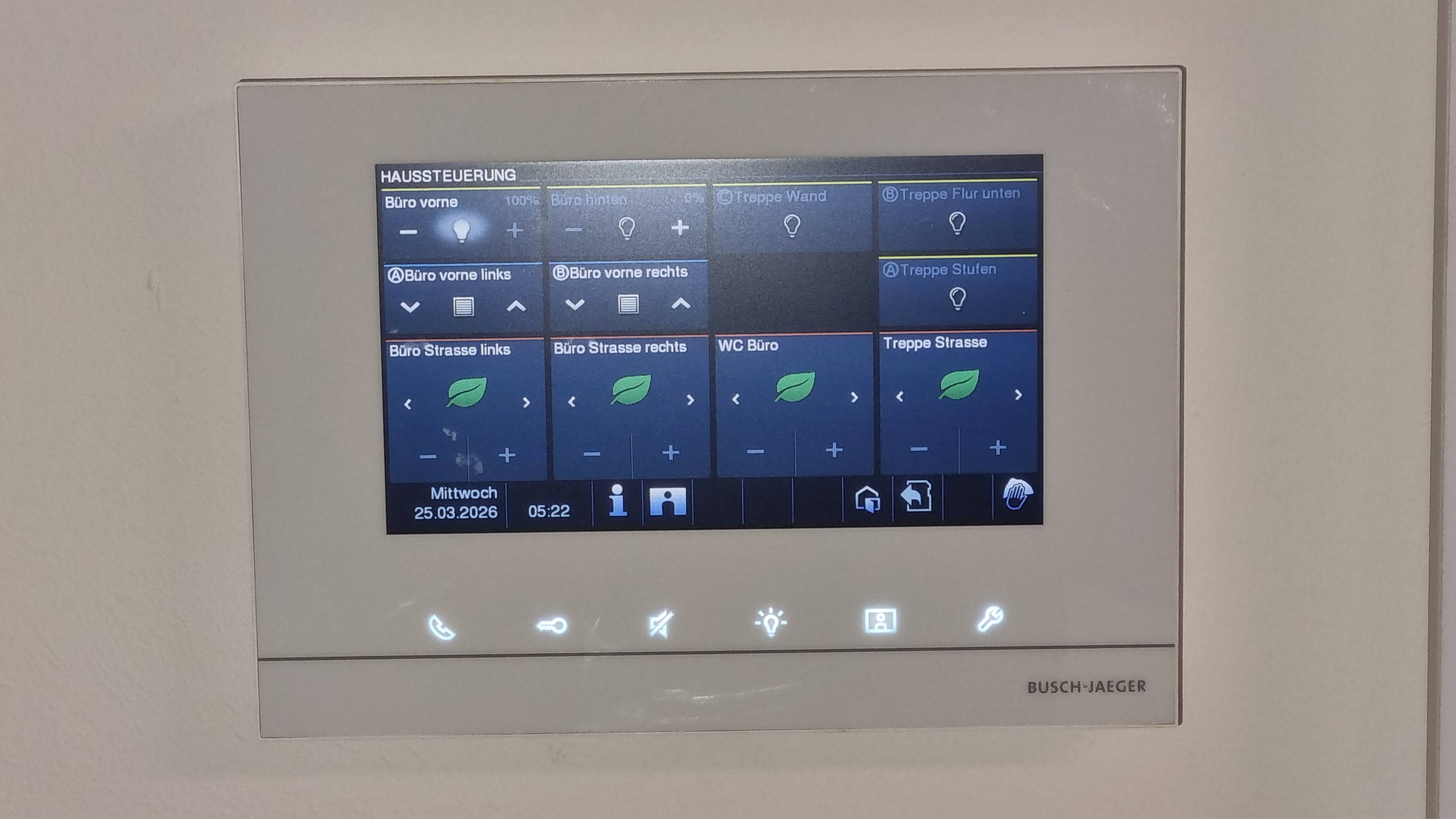 Touchdisplay an einer weißen Wand mit farbigem Interface und Anzeigen zu Bürobereichen